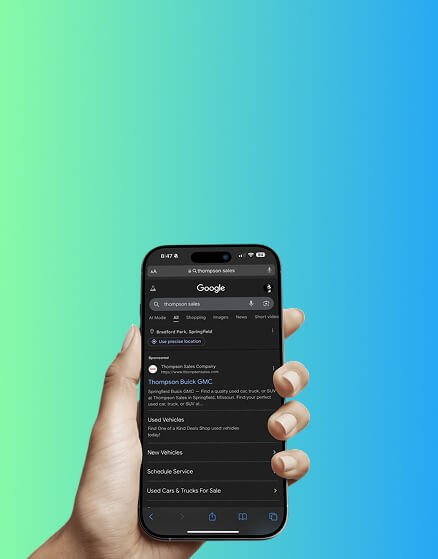 A hand holds a smartphone displaying a Google search page on a dark mode screen, with a blue and green gradient background.