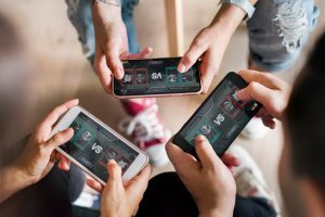Three friends playing a game on a mobile device