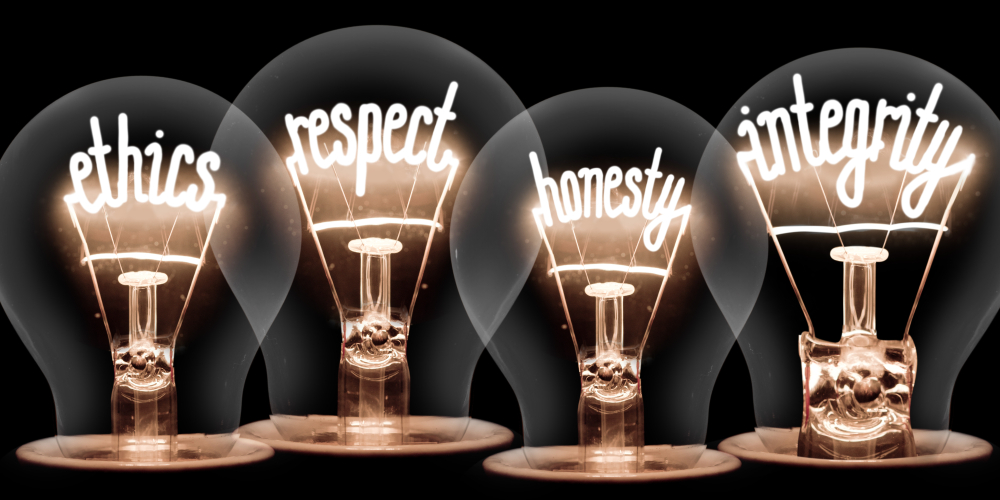 Words respect, ethics, honesty, and integrity lit inside light bulbs